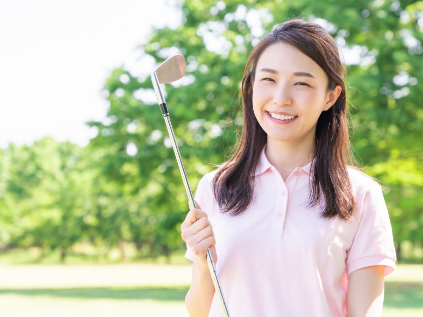 トムズビジョンの特徴3　ゴルフクラブを持った女性が笑っている画像